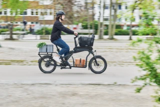 Ein Mann fährt mit einem Ca Go CS über einen Fahrradweg innerorts.