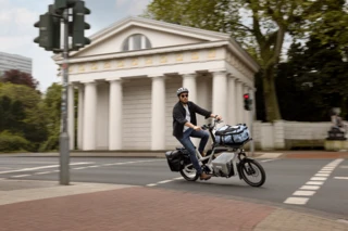 Ein Mann fährt auf einem CS über eine Straße in der Stadt.