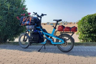 Das voll beladene Ca Go CS steht auf einem Parkplatz vor einem Strand.