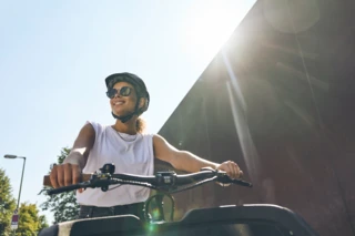 Eine junge Frau sitzt auf dem Ca Go FS200 Life. Die Sonne scheint. Sie lächelt und trägt eine Sonnenbrille.